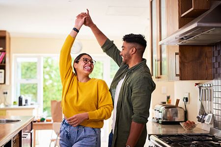 A young couple dancing together in their kitchen