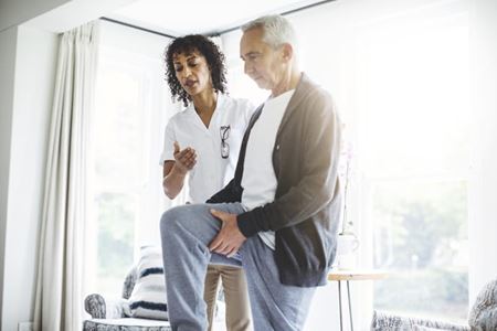 A health care professional helping a patient with exercise