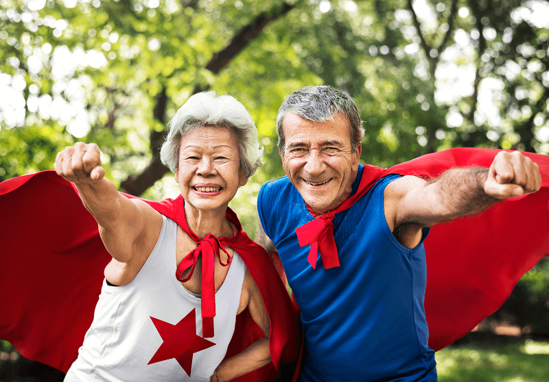 dos personas mayores con capas de superhéroe